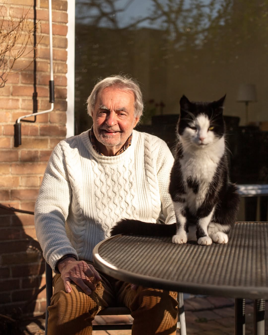 Kan een afbeelding zijn van 1 persoon, kat, steenmuur en buitenshuis