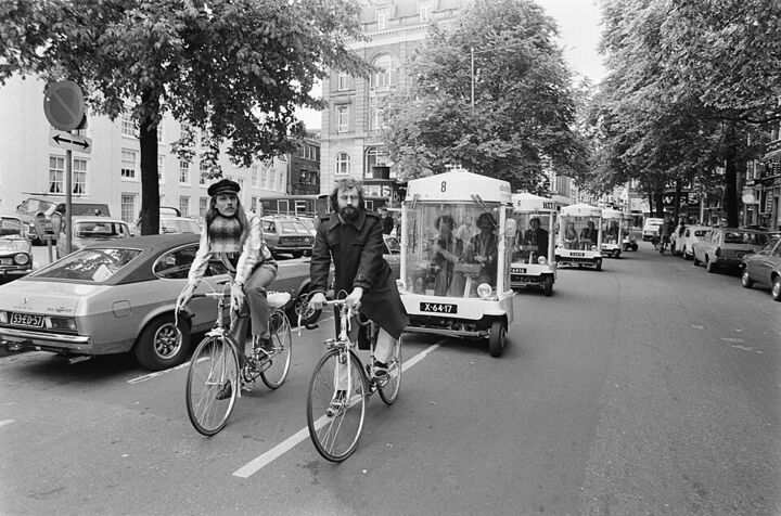 Van Duijn op de fiets, gevolgd door witkarren
